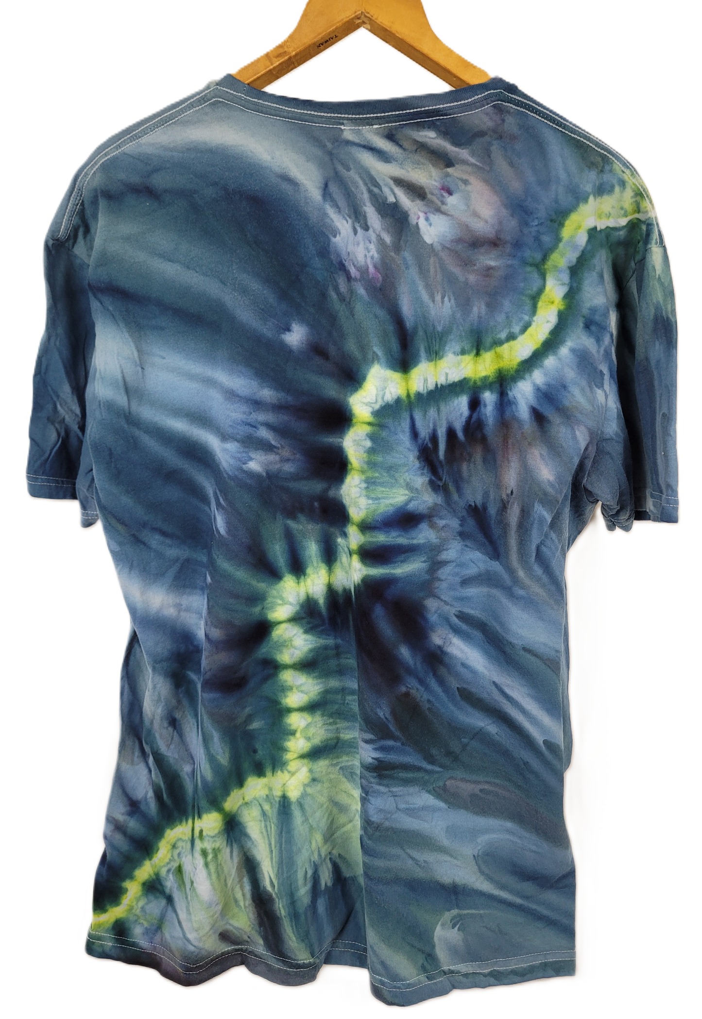 Tie-dye t-shirt with blue and green patterns on a hanger