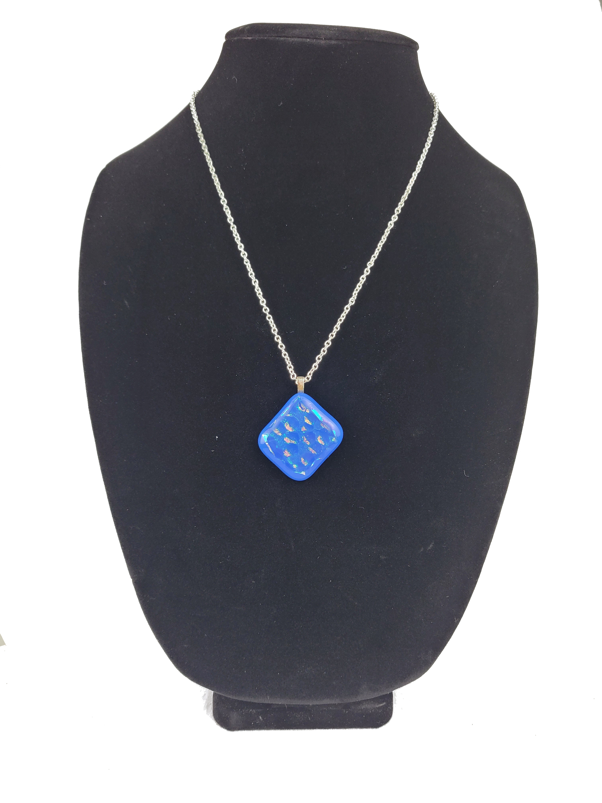 Blue pendant necklace on a black mannequin bust