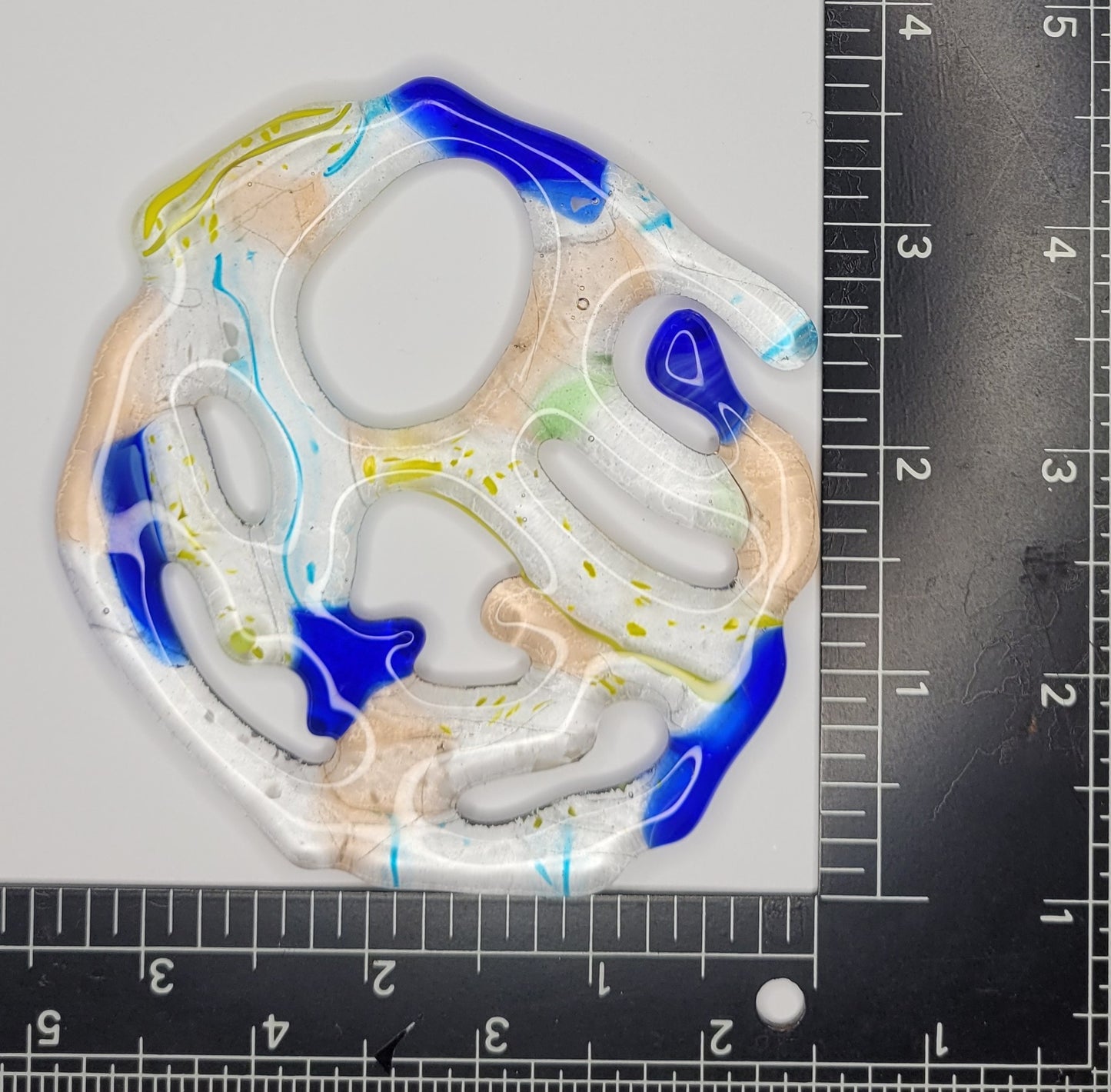 Colorful abstract design on a white background with a ruler for scale.