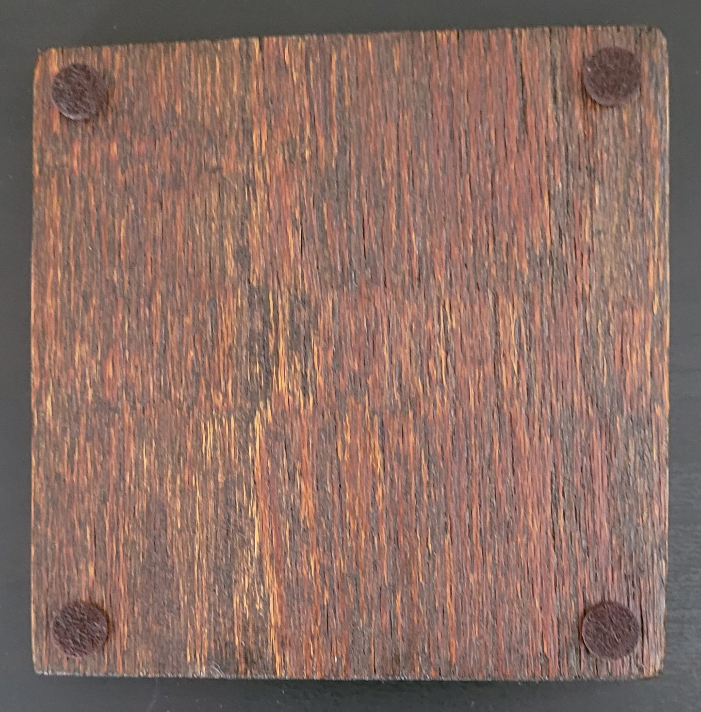 Bottom of wooden coaster with four felt pads.