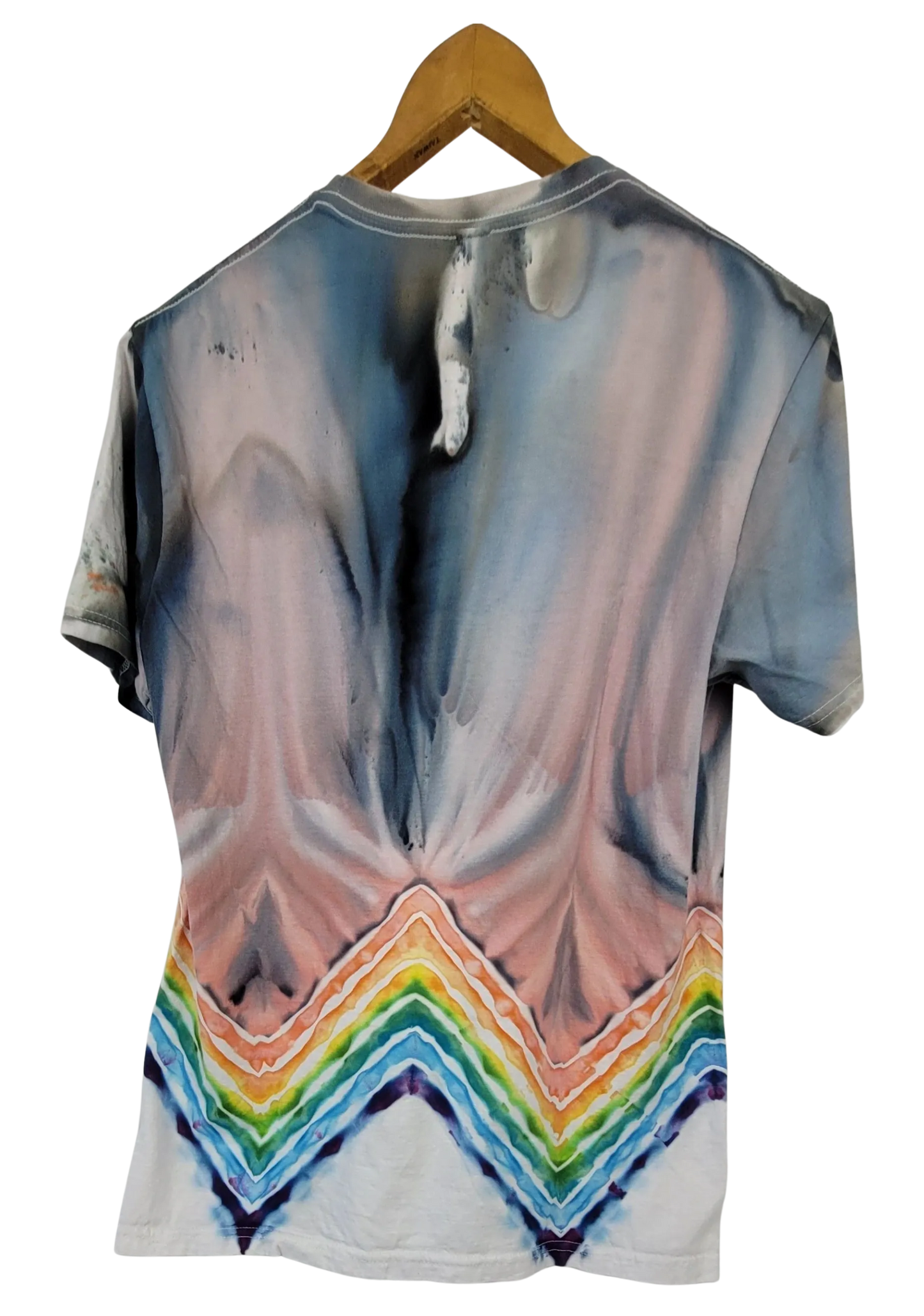 T-shirt with a tie-dye design featuring a rainbow at the bottom, hanging on a wooden hanger.