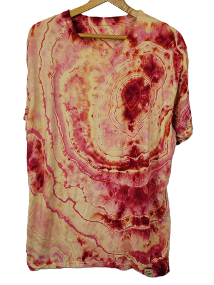 Tie-dye shirt with pink and beige patterns on a hanger