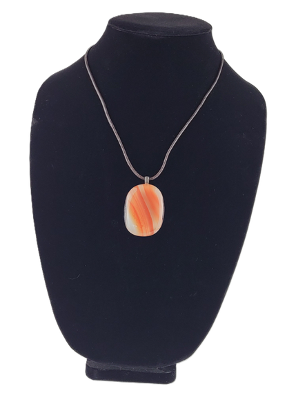 Necklace with an orange pendant on a black velvet stand