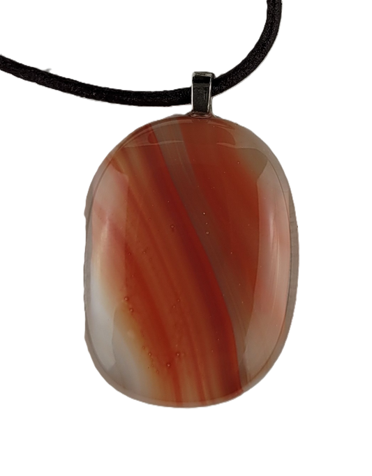 Oval-shaped fused glass pendant on a black cord against a white background