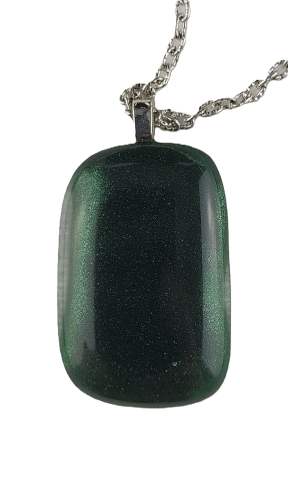 Green glass pendant on a chain against a white background