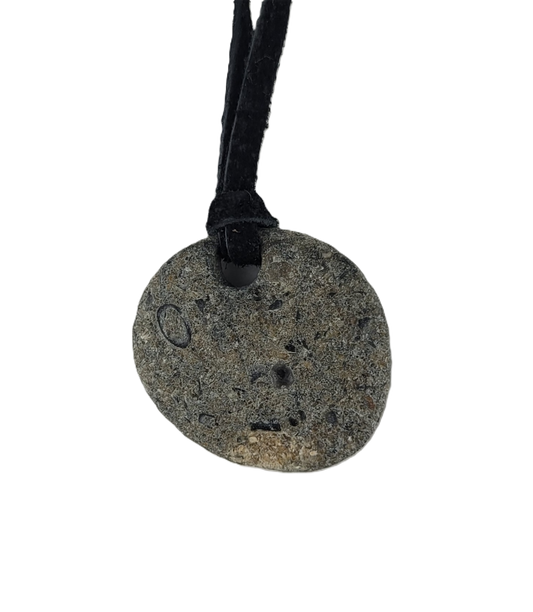 Round stone pendant on a black cord against a white background
