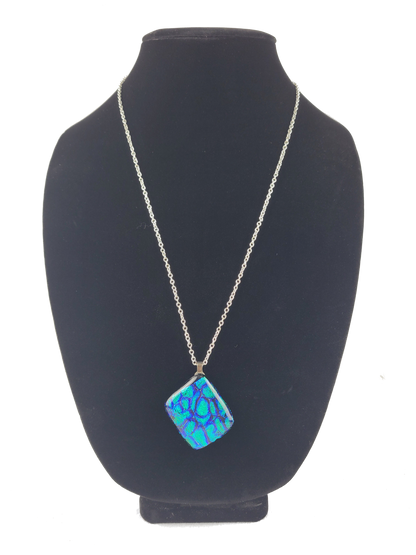 Necklace with a blue pendant on a black mannequin bust