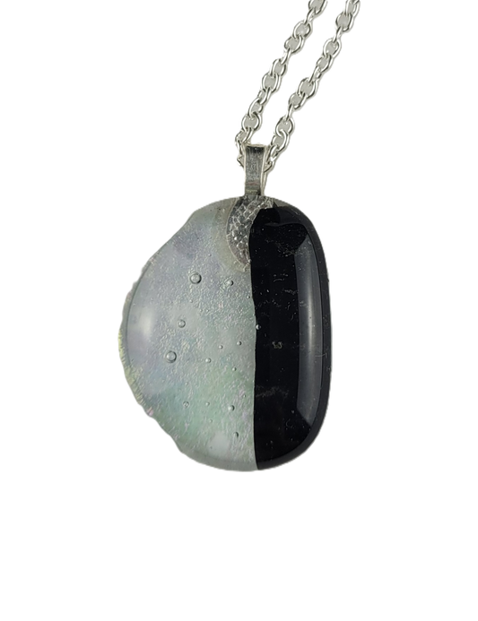 Necklace with a half-black, half-white pendant on a white background