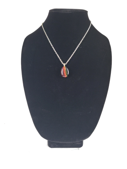 Necklace with a colorful pendant on a black velvet stand