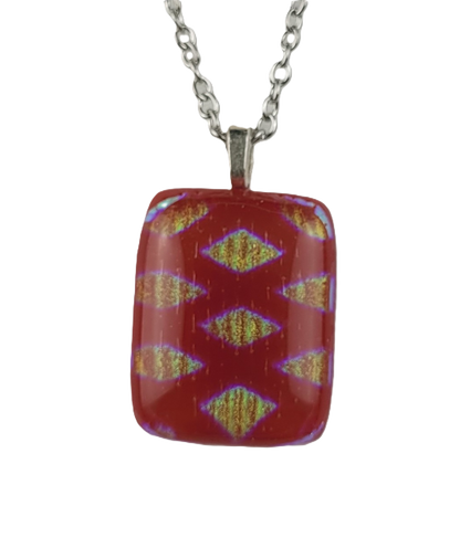 Red pendant with a pattern on a silver chain against a white background