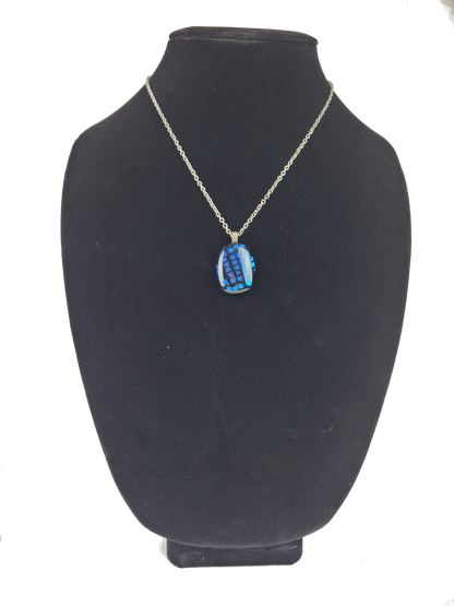 Necklace with a blue pendant on a black mannequin bust