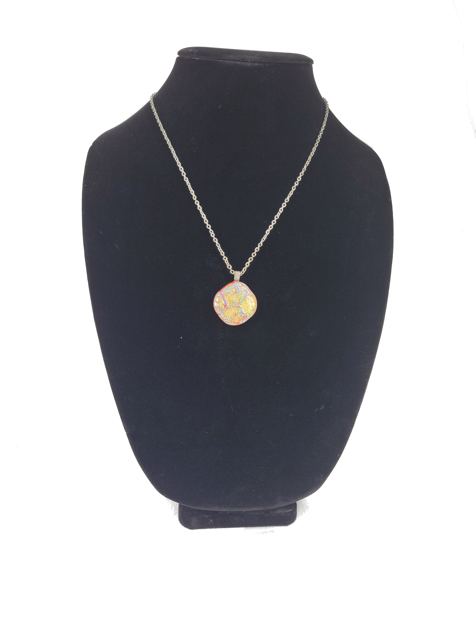 Necklace with a pendant on a black velvet stand against a white background