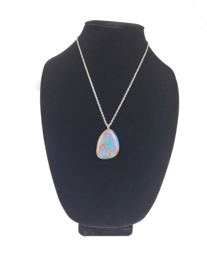 Necklace with a pendant on a black bust against a white background