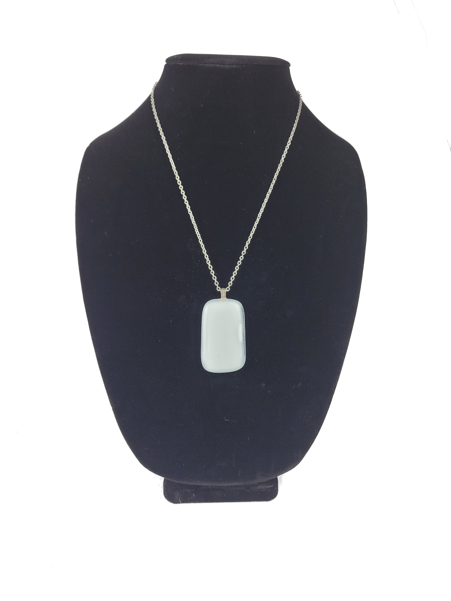 Necklace with a pendant on a black bust against a white background
