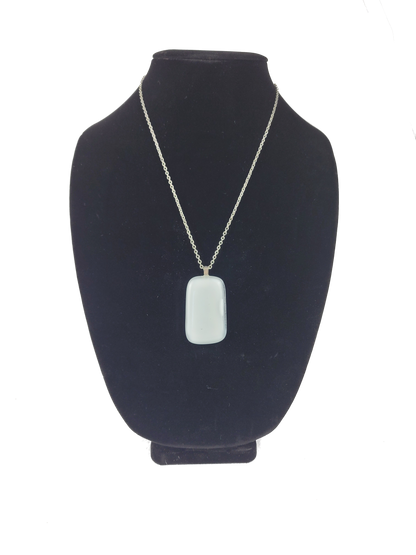 Necklace with a pendant on a black bust against a white background