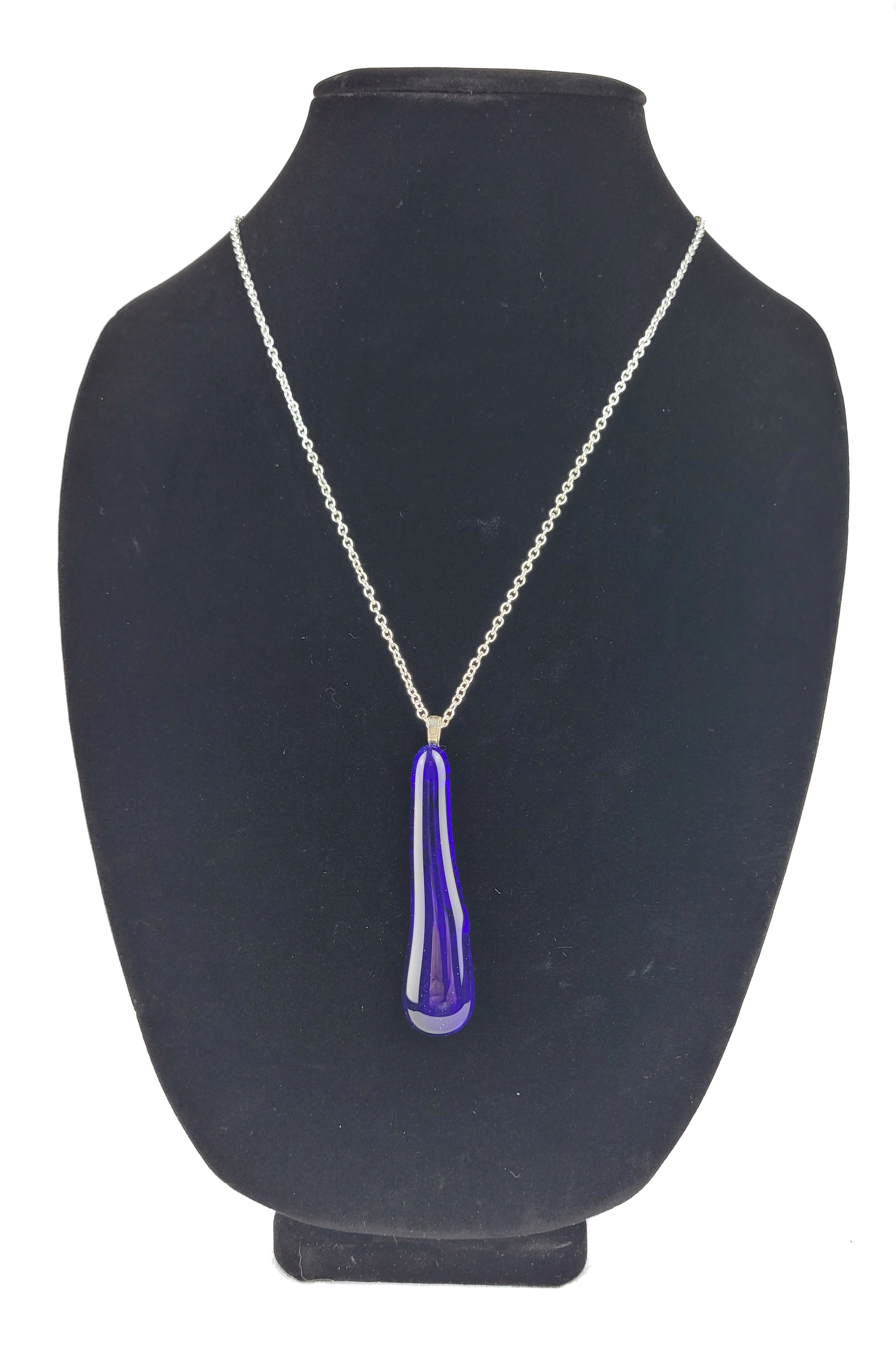 Necklace with a blue pendant on a black mannequin bust