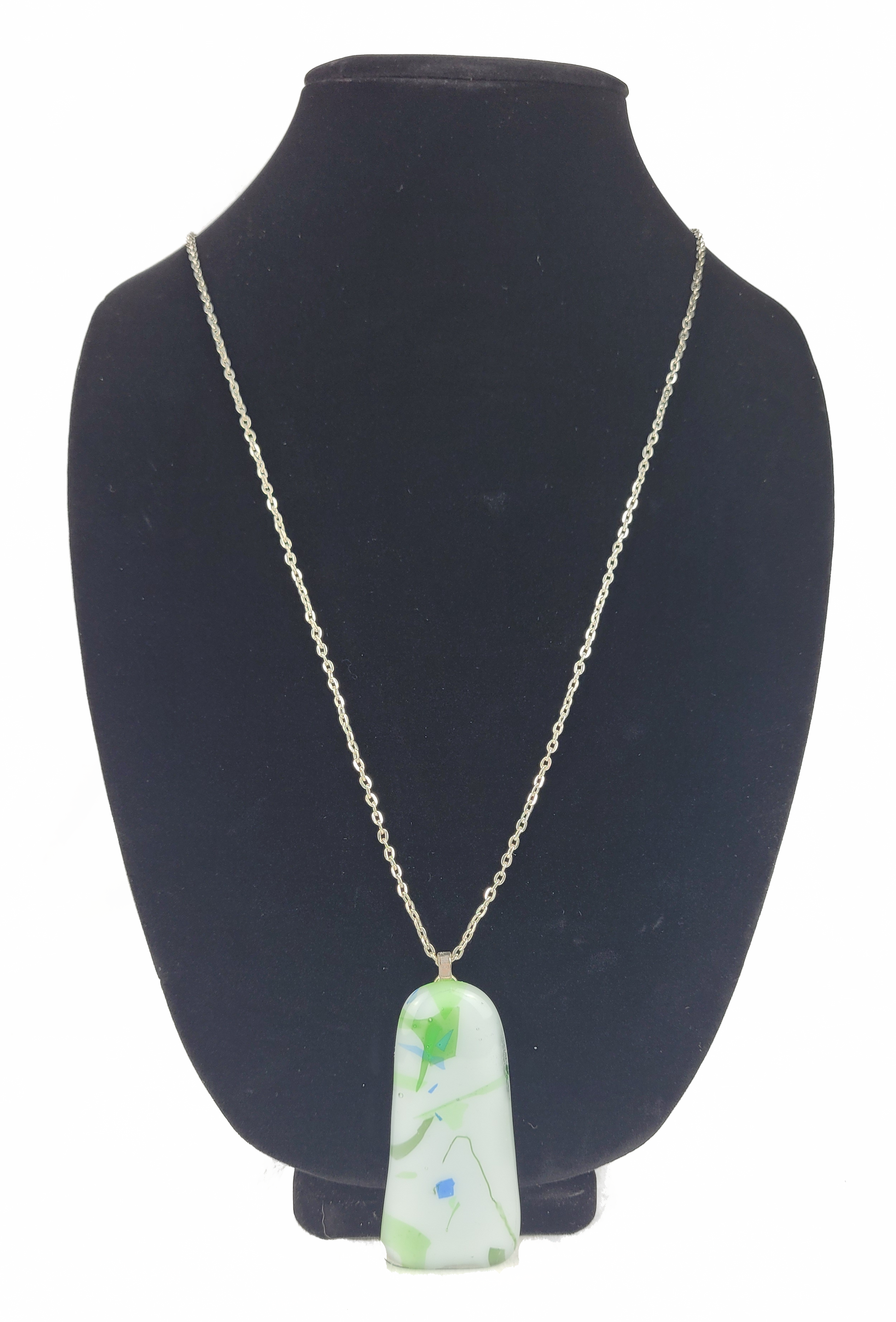 Necklace with a green pendant on a black mannequin bust