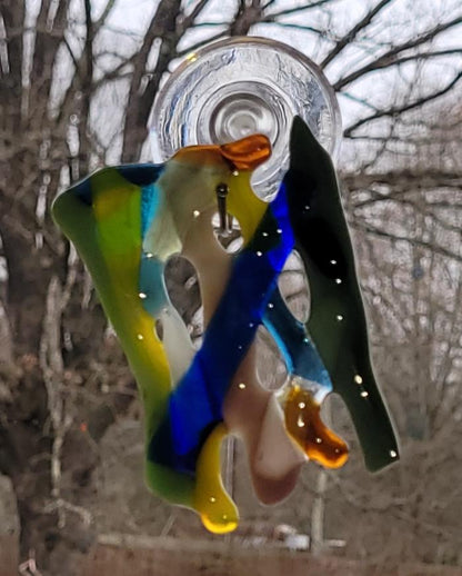 Colorful glass hanging decoration against a blurred natural background