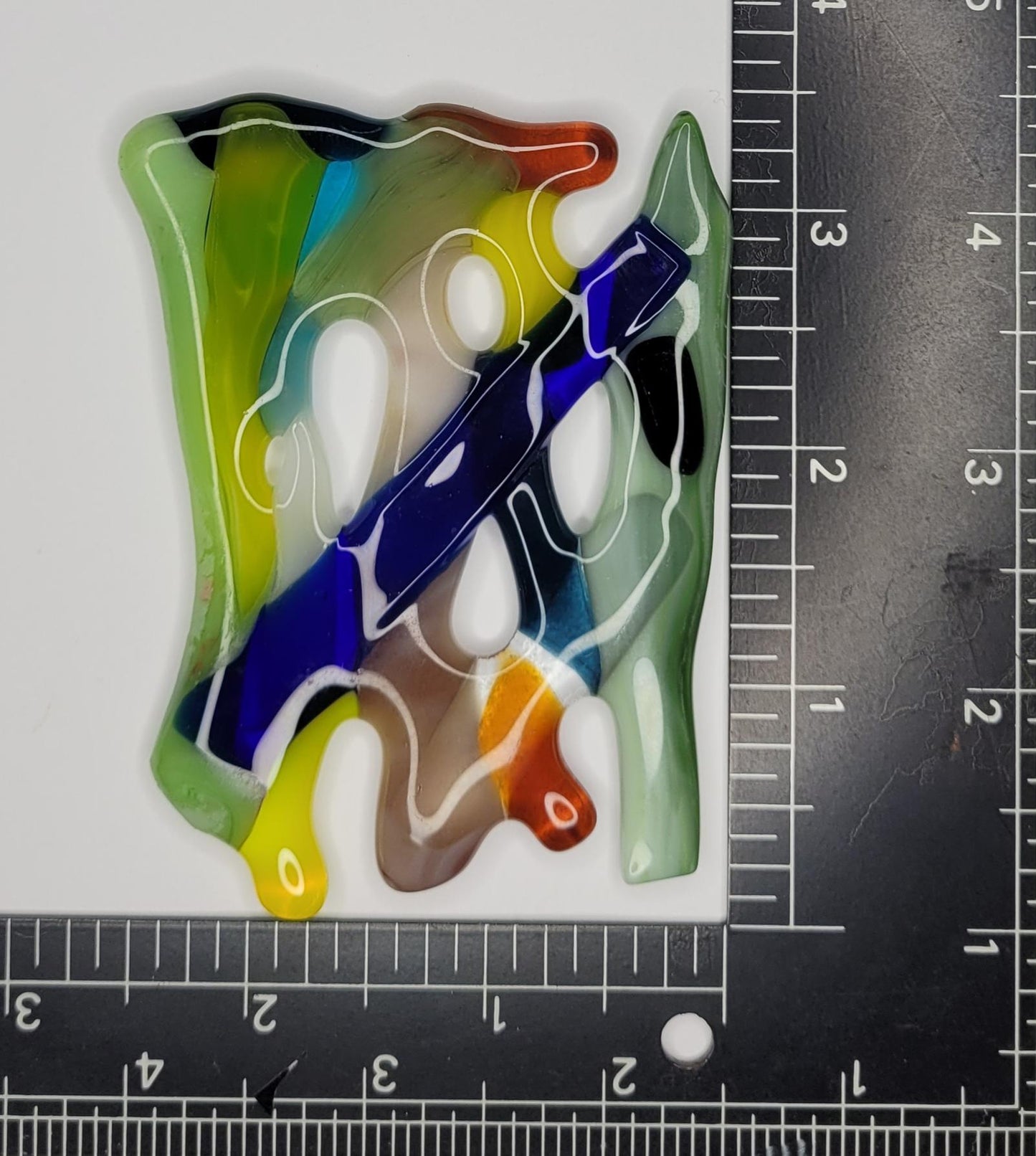Colorful abstract design on a white background with a ruler for scale.