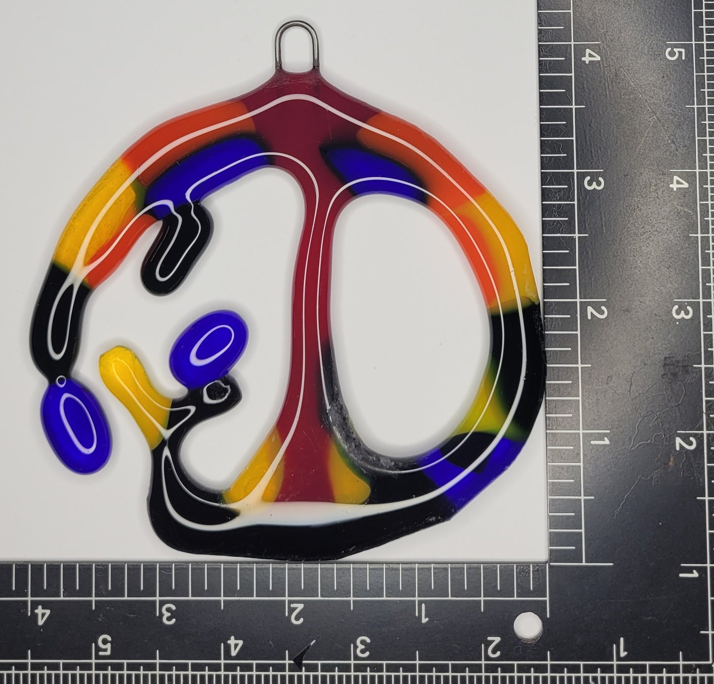 Colorful abstract design on a white background with a ruler for scale.