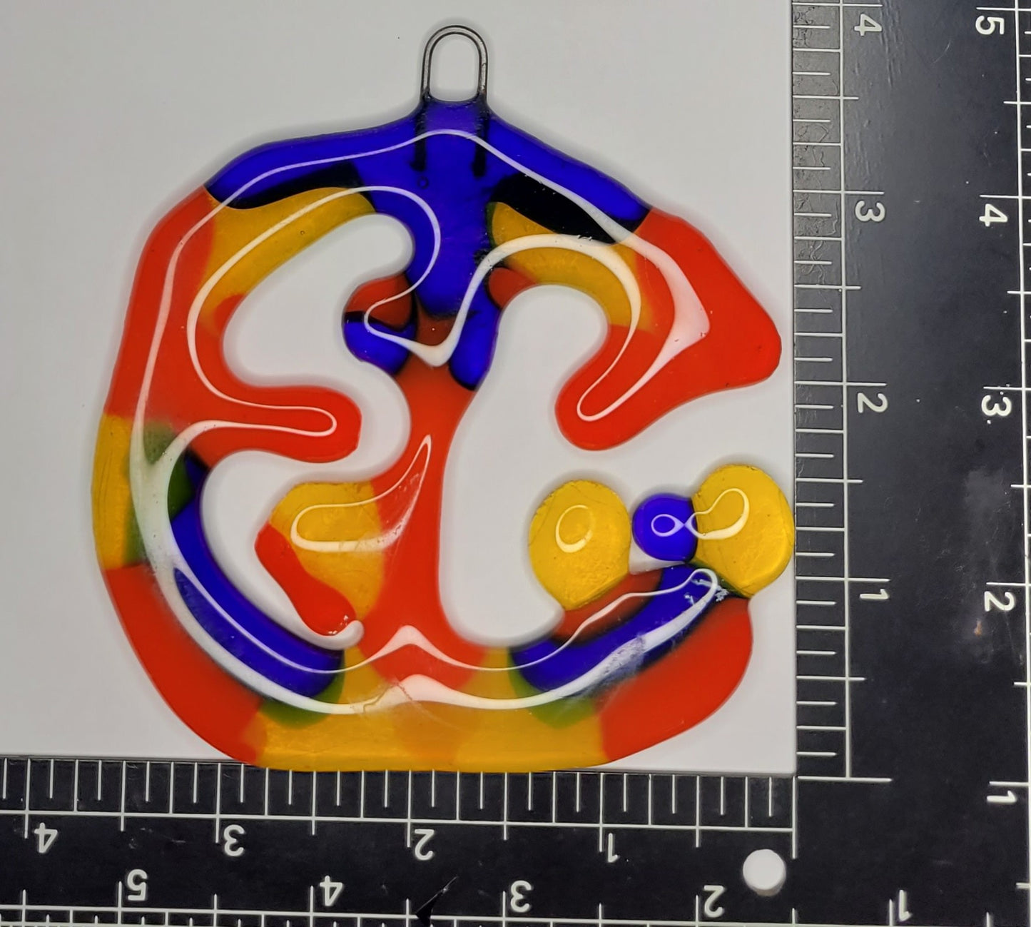 Colorful abstract design on a white background with a ruler for scale.