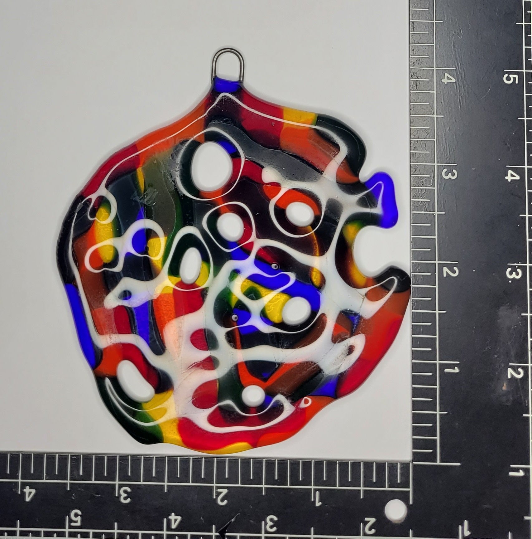 Colorful abstract design on a white background with a ruler for scale.