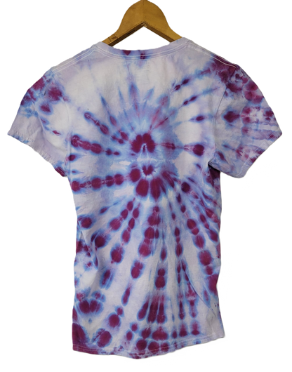 Tie-dye t-shirt with a spiral pattern on a hanger against a white background
