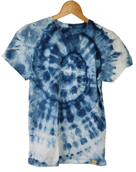 Tie-dye t-shirt with blue and white spiral pattern on a hanger against a white background