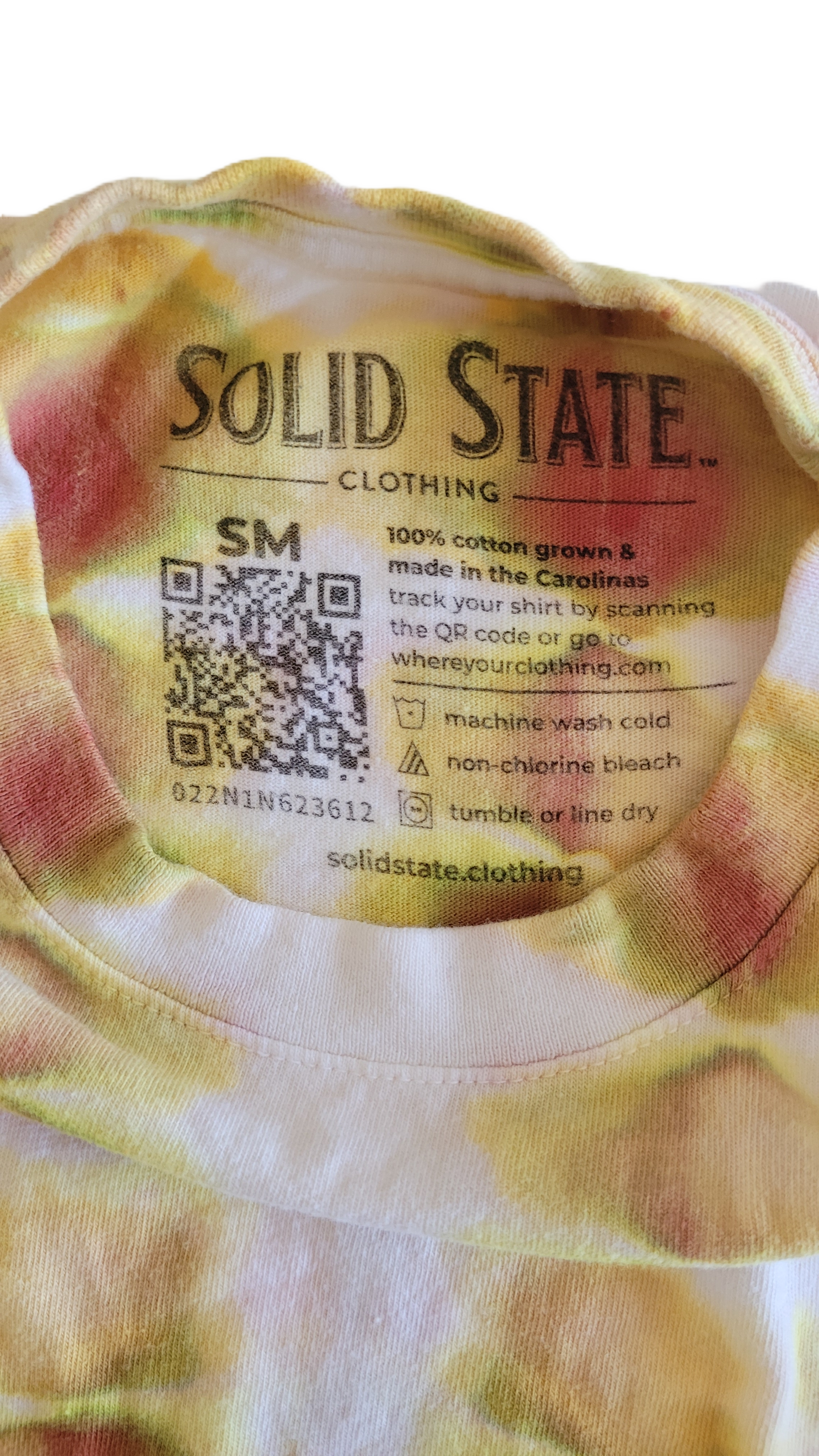 Back of a tie-dye shirt with 'Solid State Clothing' label and QR code.