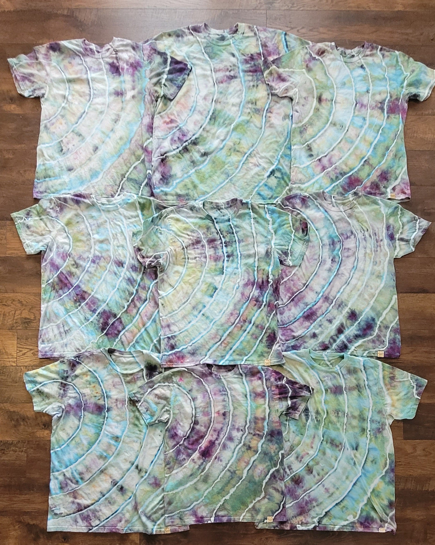 Set of tie-dye t-shirts on a wooden surface