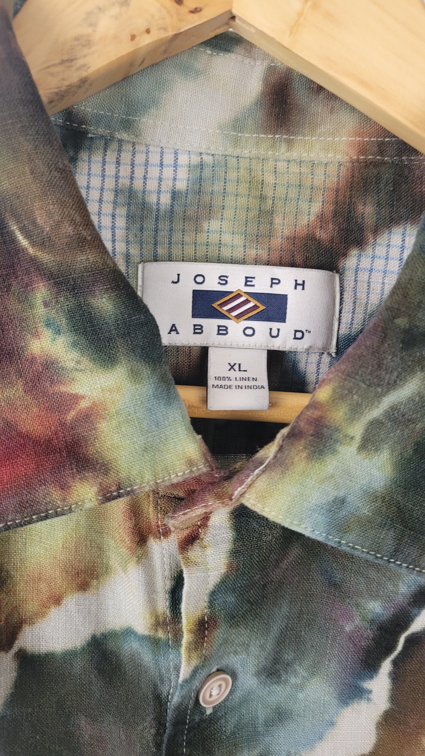 Tie-dye shirt with a Joseph Abboud label on a wooden surface