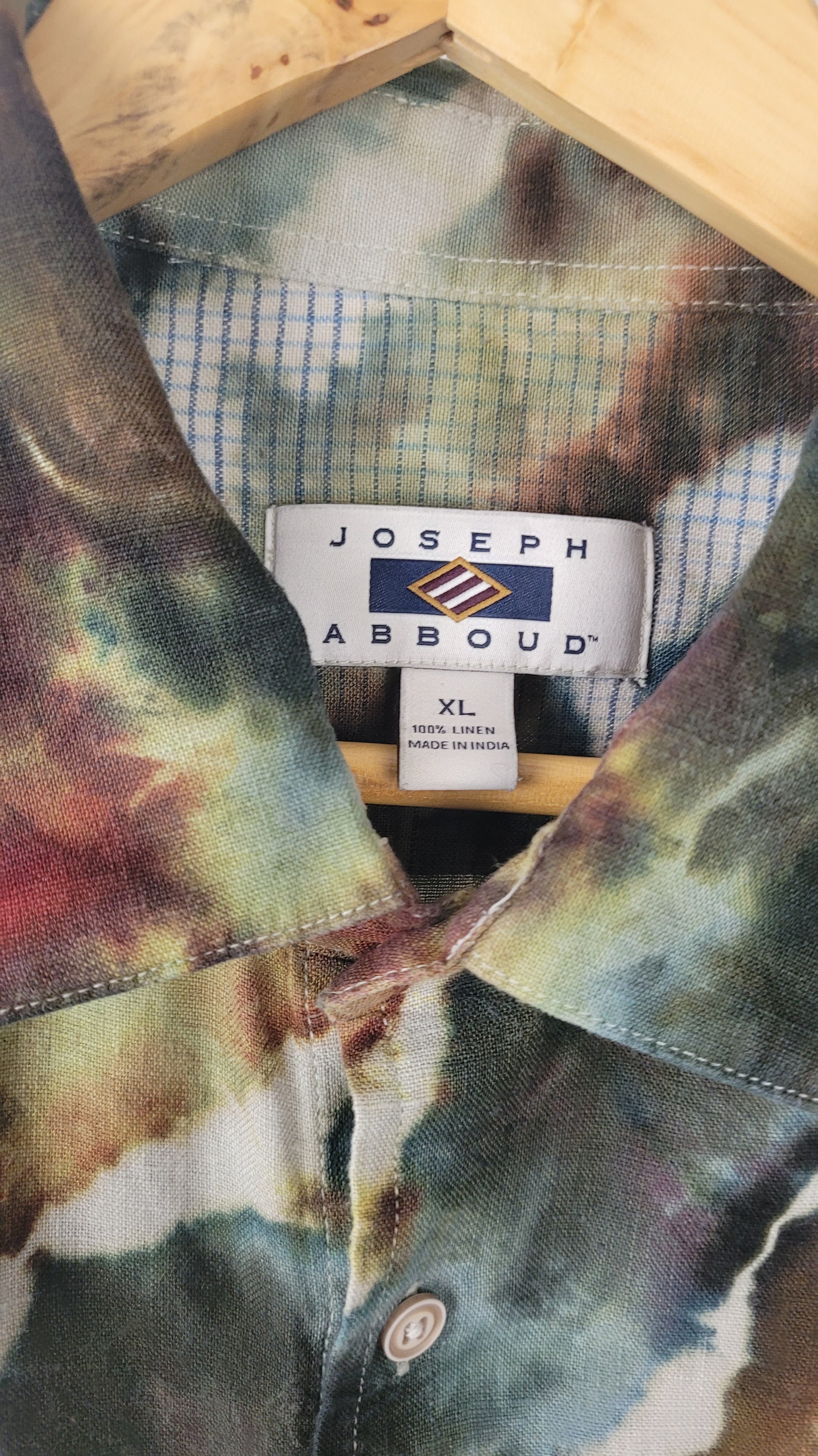 Tie-dye shirt with a Joseph Abboud label on a wooden surface