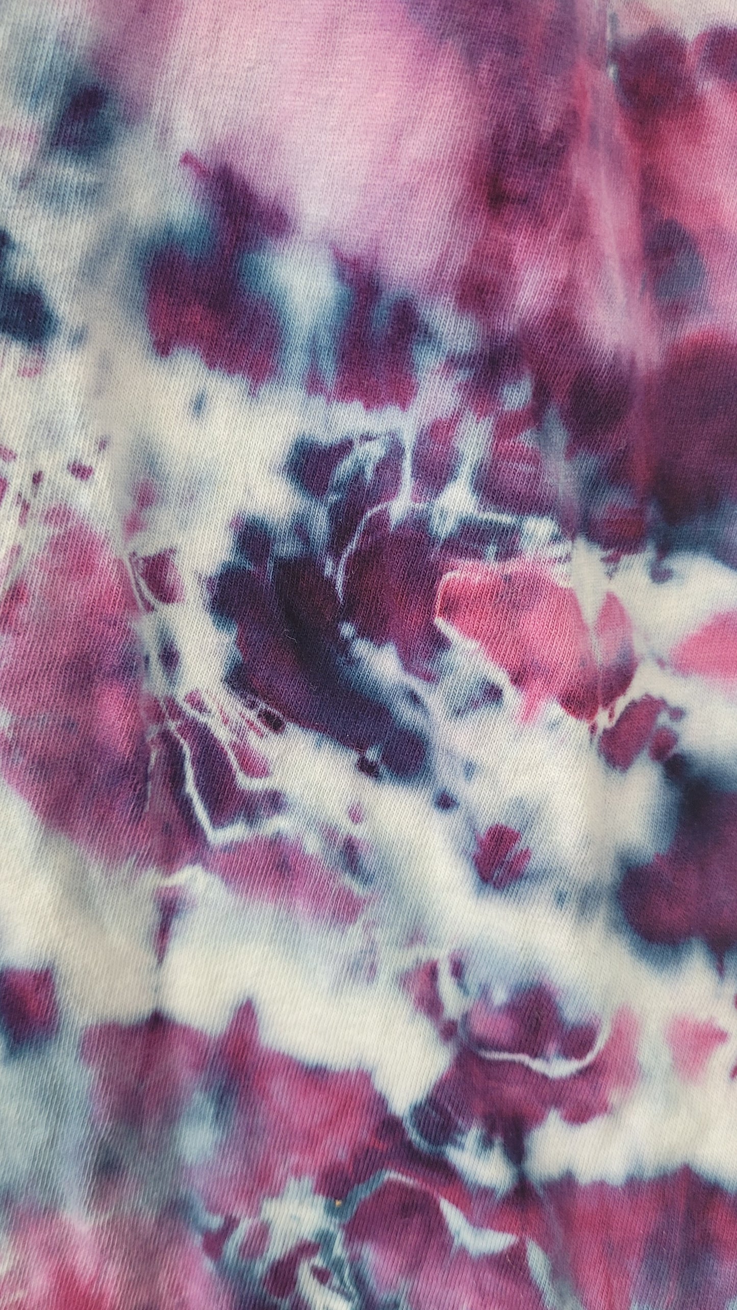 Close-up of tie-dye fabric with pink, white, and black colors.