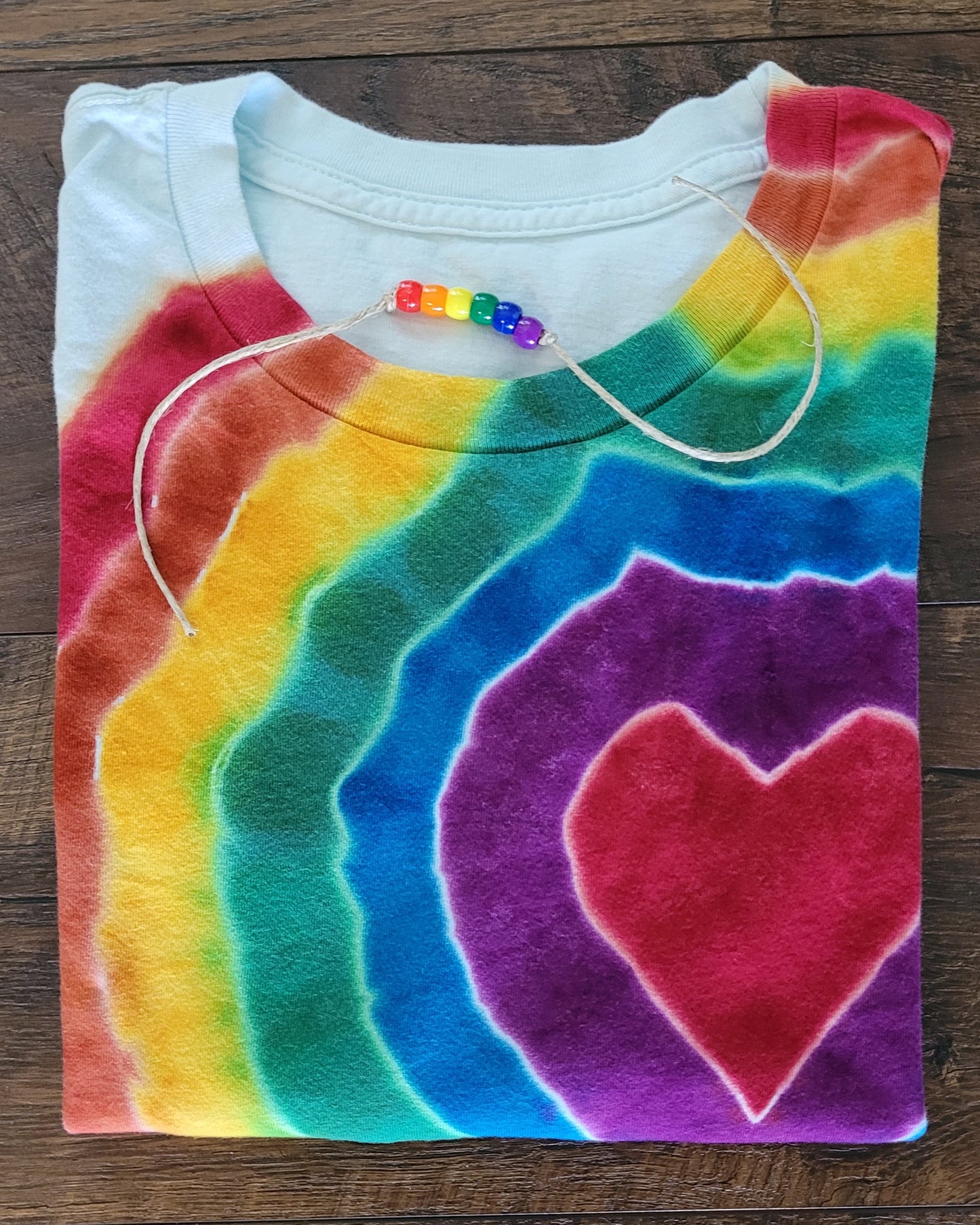 Tie-dye shirt with a heart design on a wooden surface