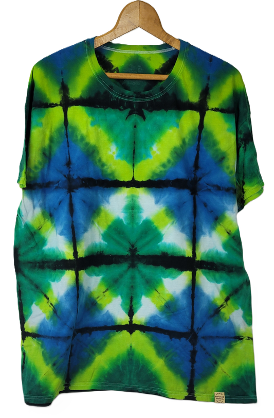 Tie-dye t-shirt with green, blue, and black pattern on a hanger