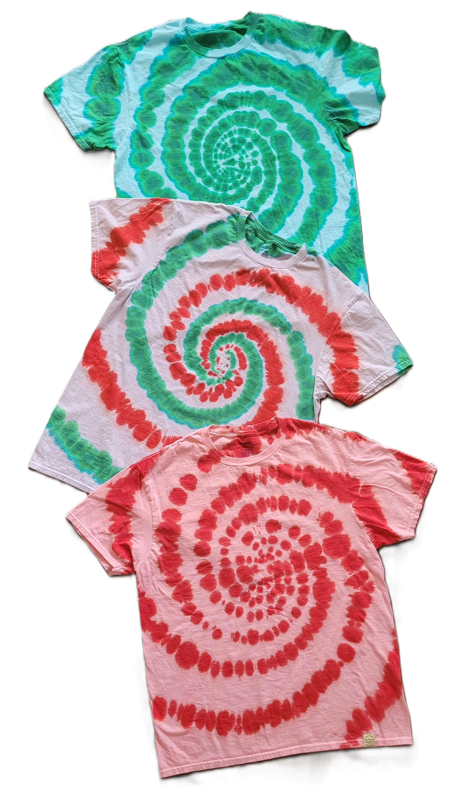Three tie-dye t-shirts with spiral patterns in green, red, and pink on a white background.