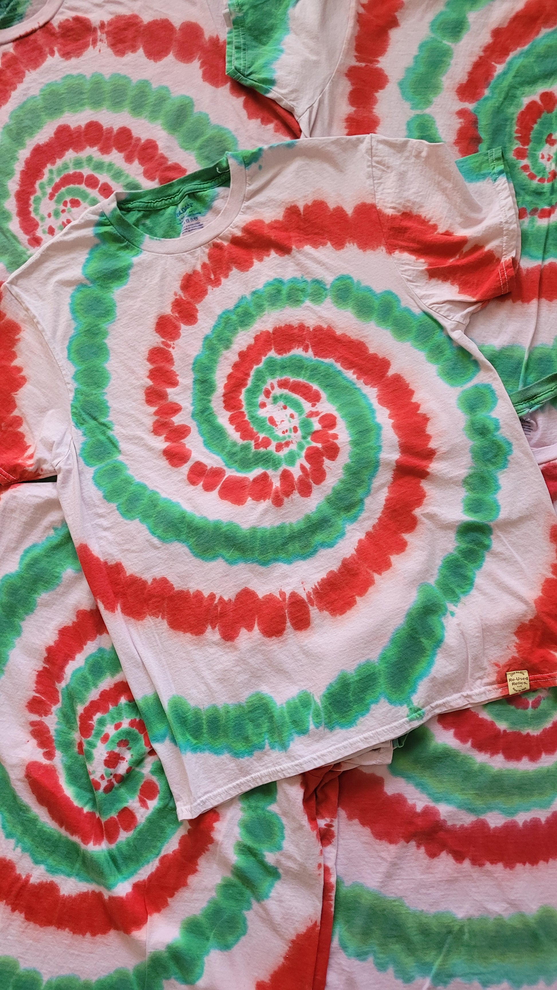 Tie-dye blanket with red and green spiral pattern on a white background