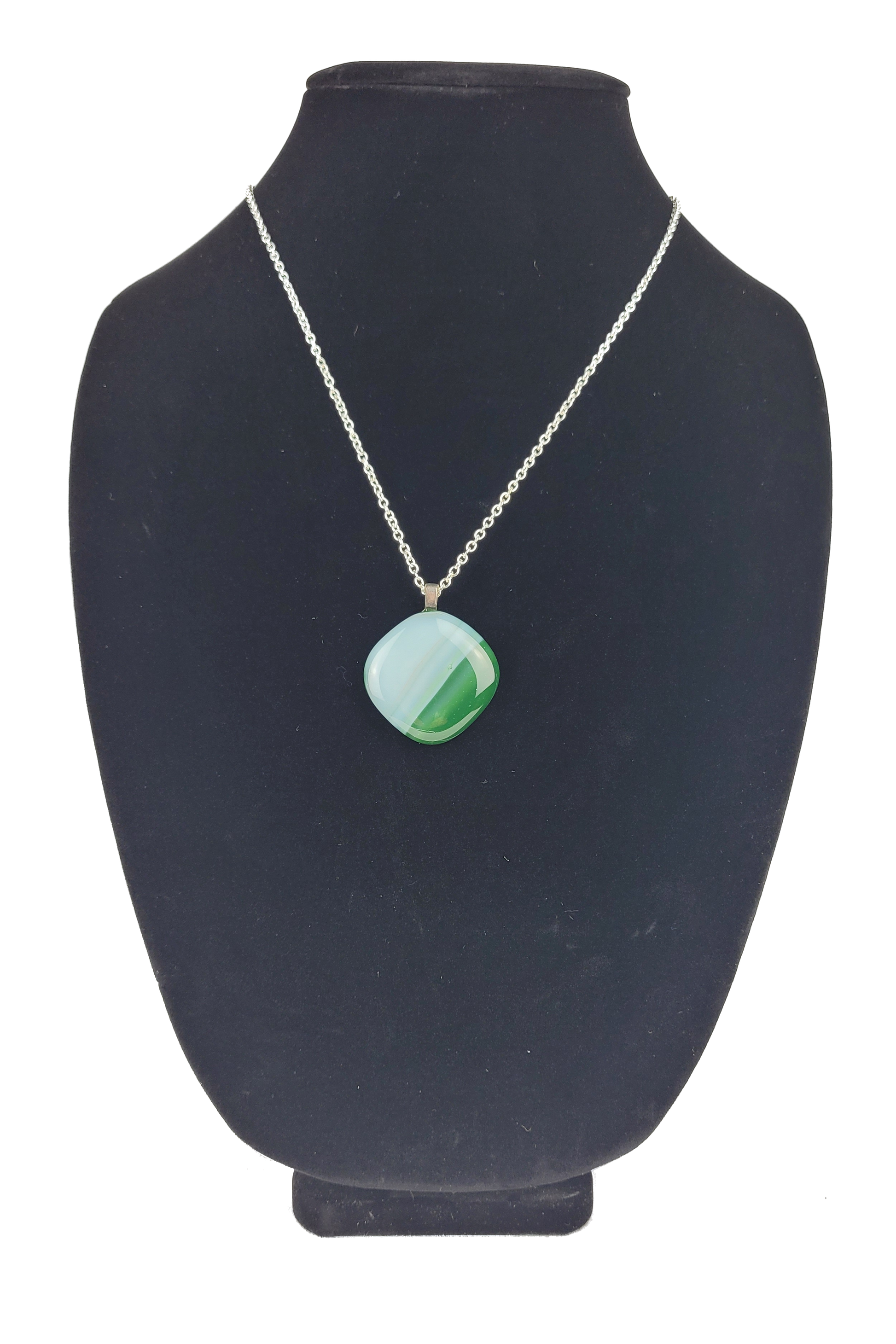 Necklace with a green pendant on a black bust