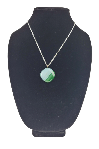 Necklace with a green pendant on a black bust