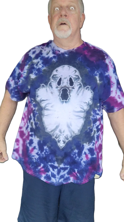 A man wearing a short-sleeve tie-dye t-shirt with a large white ghost graphic on the front, featuring blue, purple, and pink tie-dye patterns.