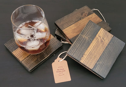 Wooden coasters with a glass of iced drink on a dark surface
