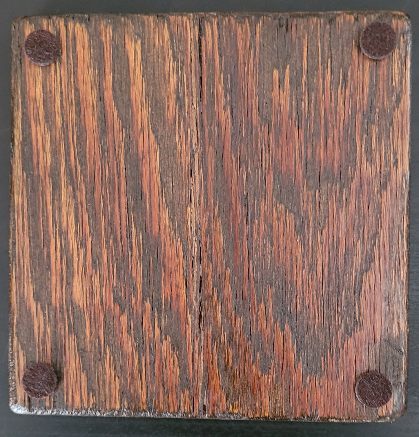 Bottom of wooden coaster with four felt pads.