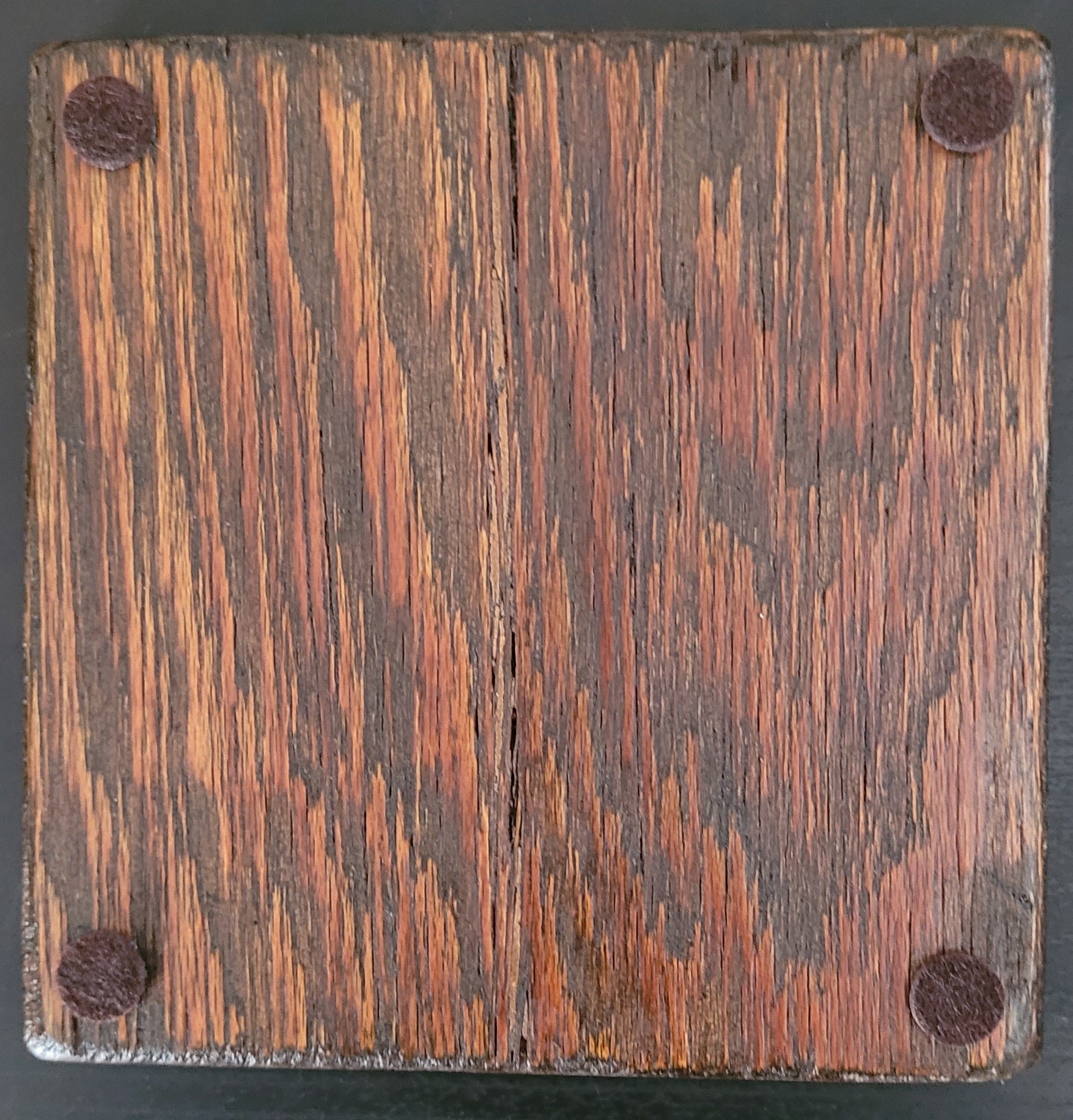 Bottom of wooden coaster with four felt pads.