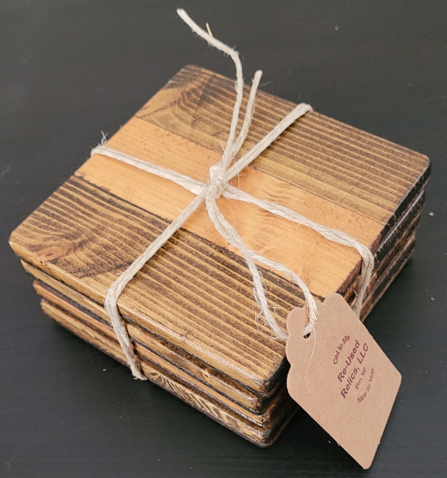 Stack of wooden coasters tied with string on a dark surface