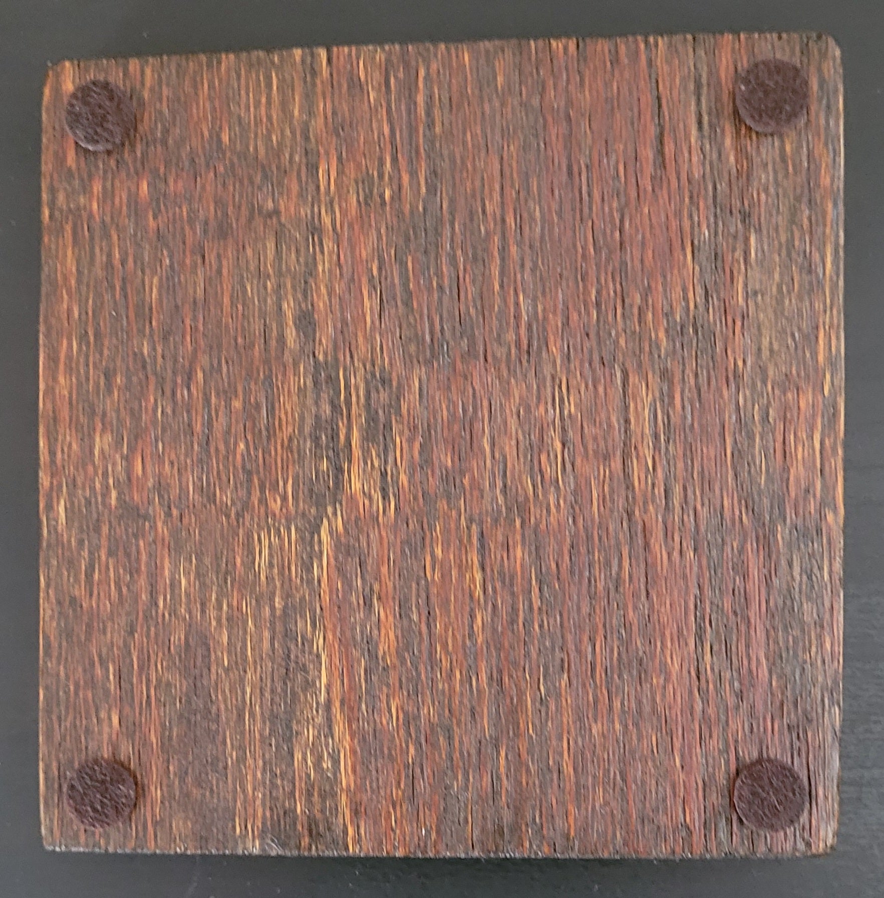 Bottom of wooden coaster with four felt pads.