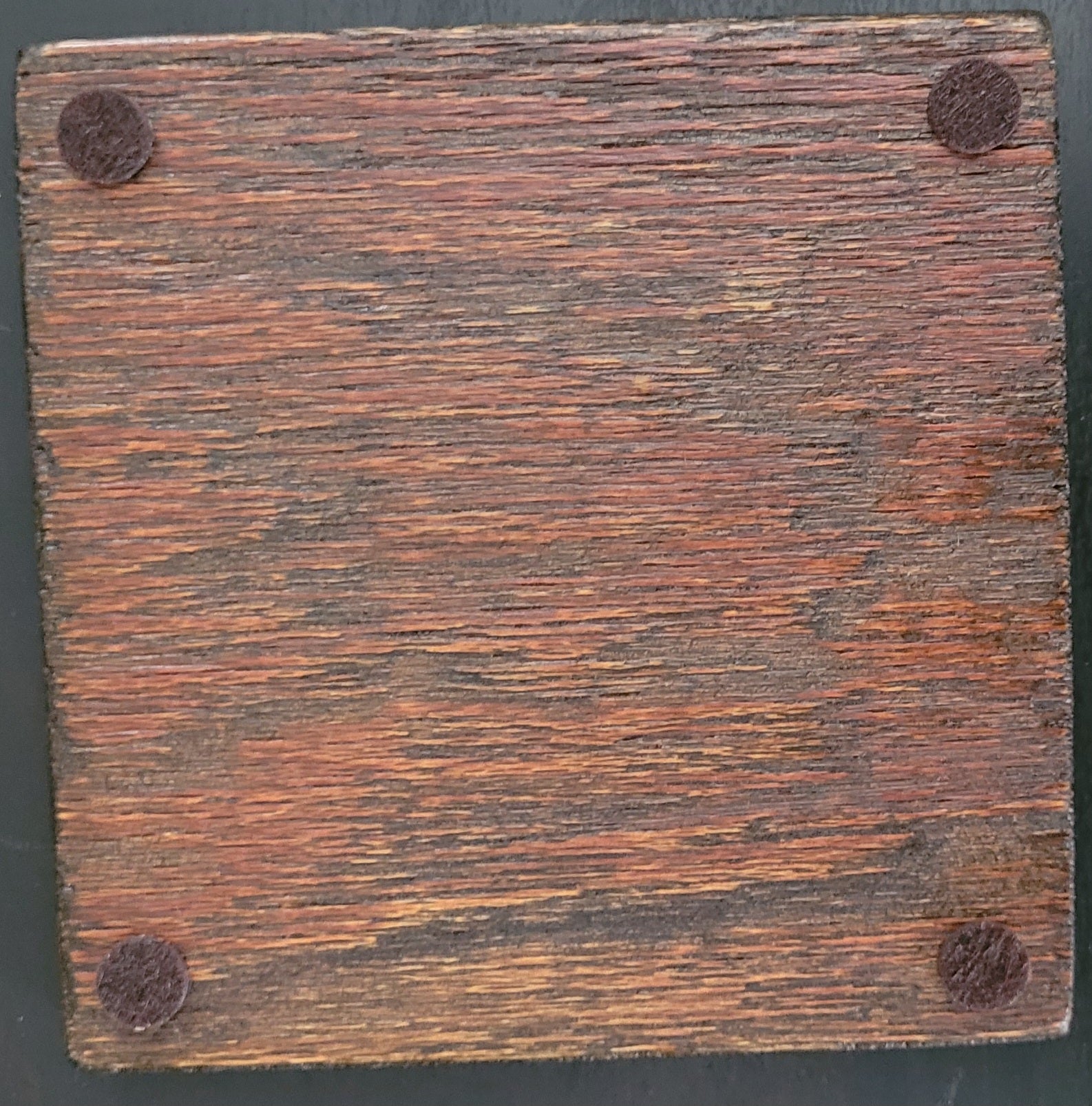 Bottom of wooden coaster with four felt pads.