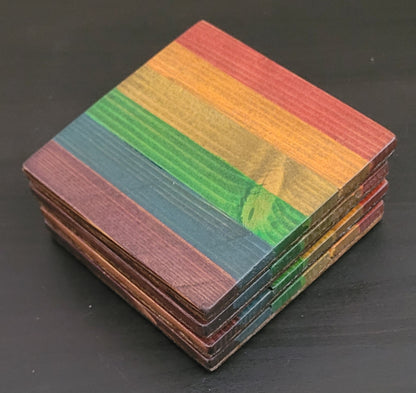 Stack of colorful wooden coasters on a dark surface