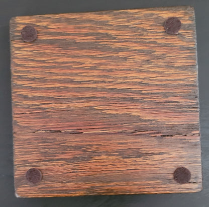 Bottom of a wooden coaster with four felt pads.