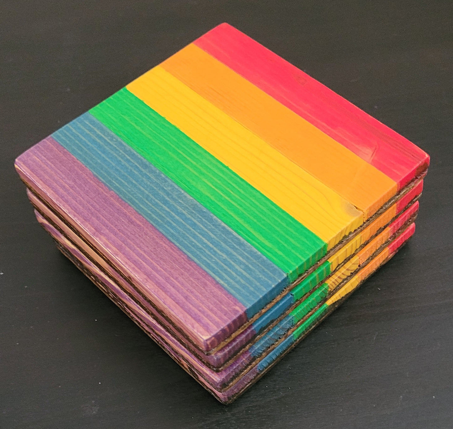 Stack of colorful coasters on a black background.