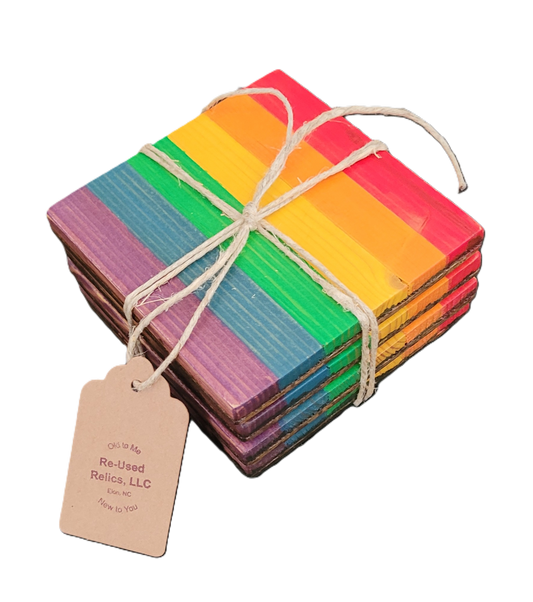 Stack of rainbow-colored coasters tied with twine on a black background, with a tag from Re-Used Relics, LLC.